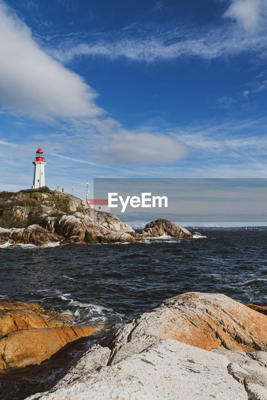 View of lighthouse by sea against sky