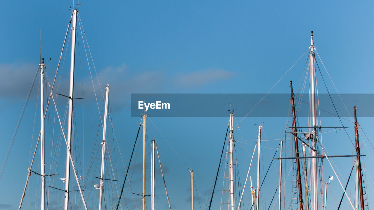 Low angle view of mast against blue sky