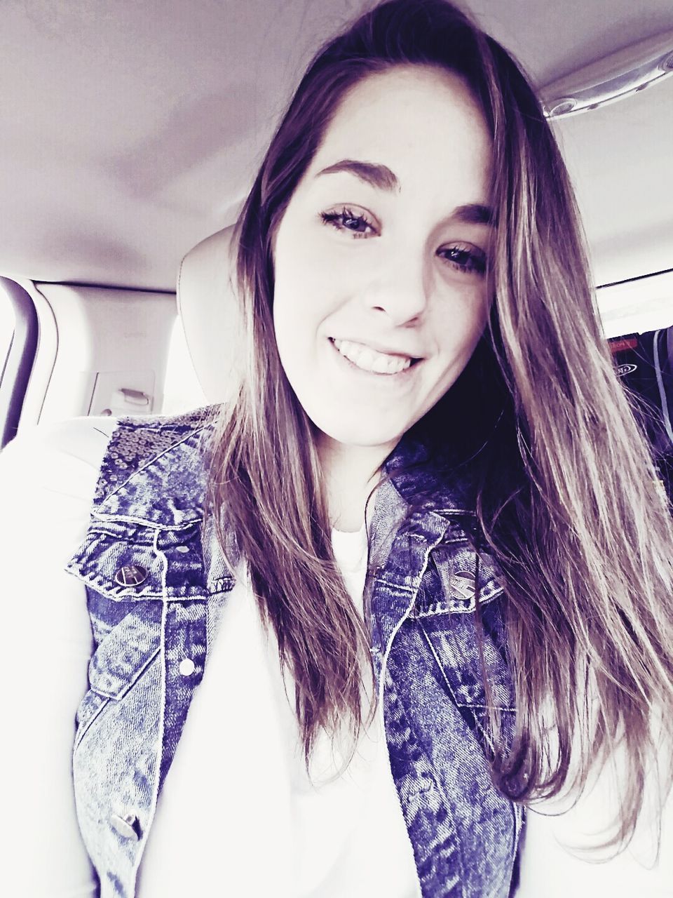 Close-up portrait of young woman smiling while traveling in car