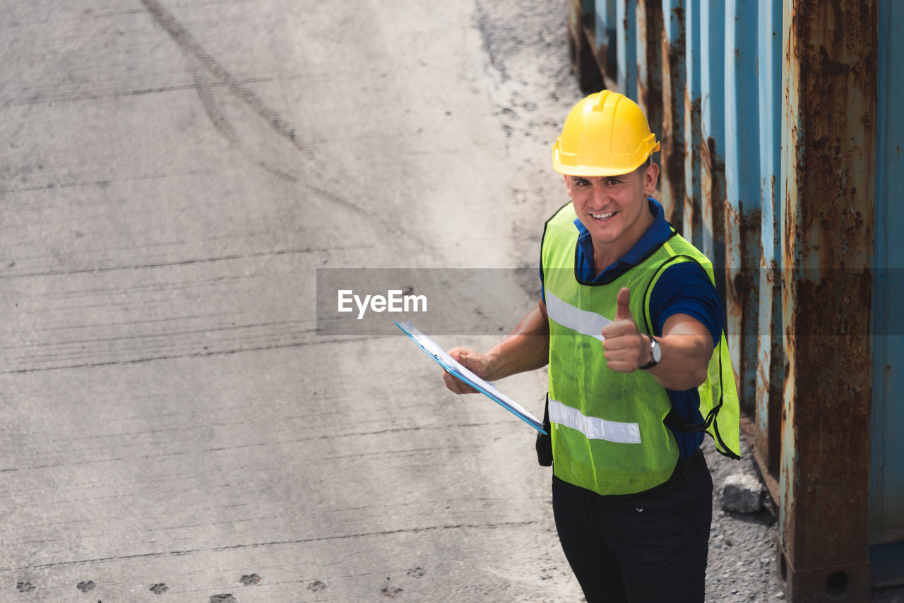 MAN WORKING WITH ARMS OUTSTRETCHED STANDING ON FLOOR