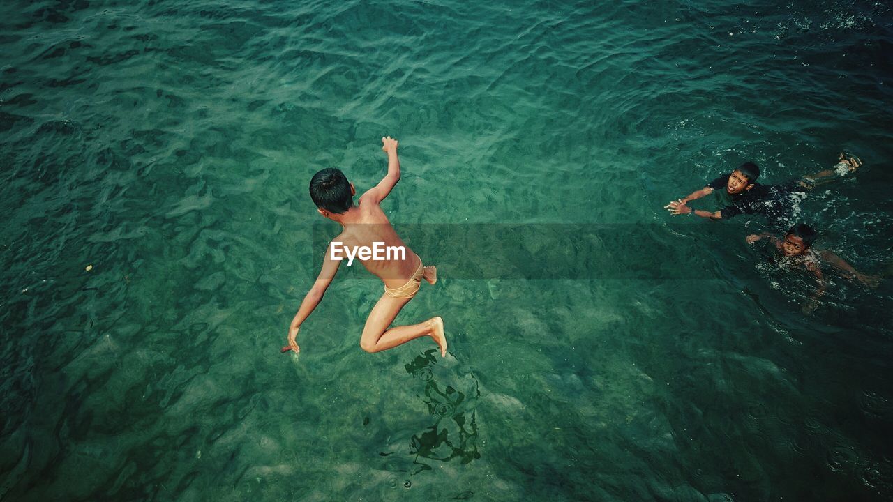 HIGH ANGLE VIEW OF WOMAN SWIMMING IN WATER