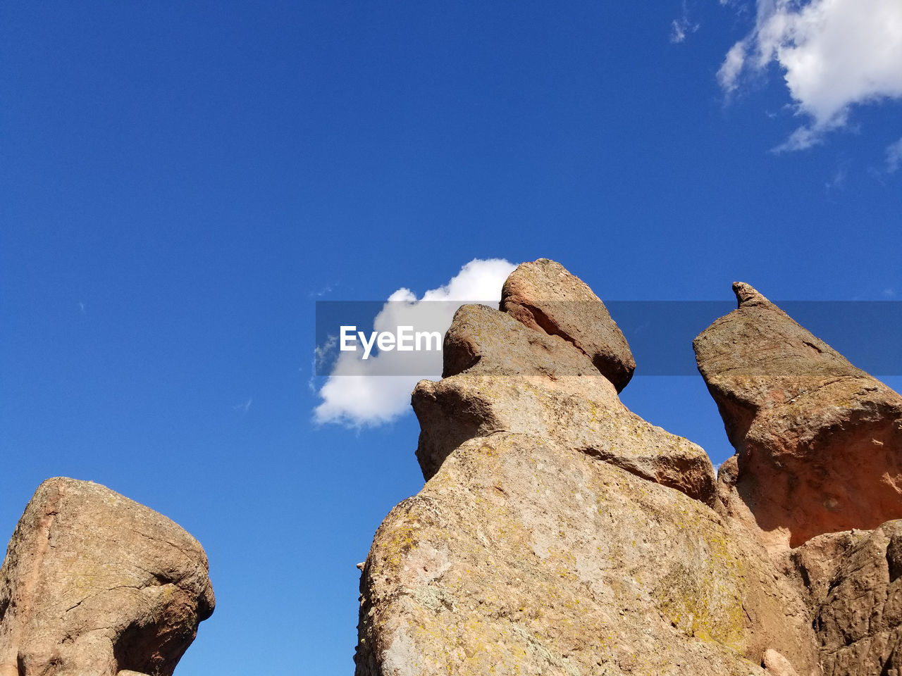 LOW ANGLE VIEW OF ROCK FORMATION AGAINST BLUE SKY