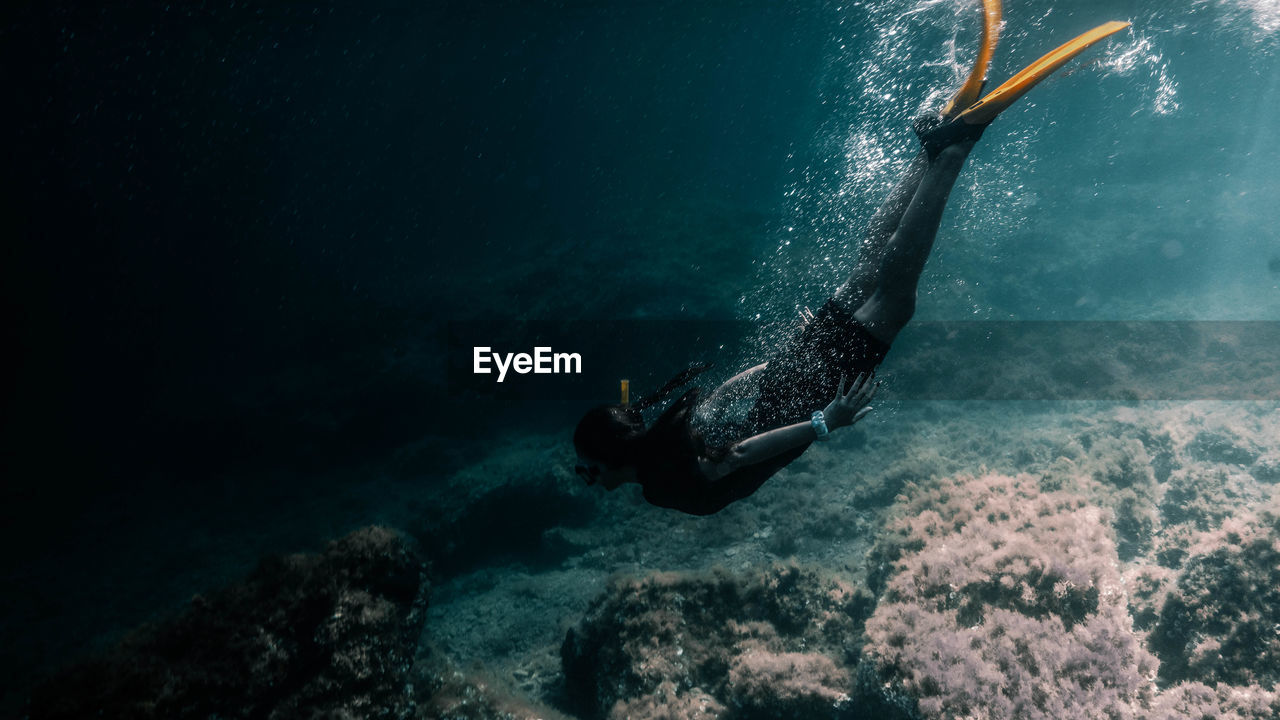 Full length of woman diving undersea