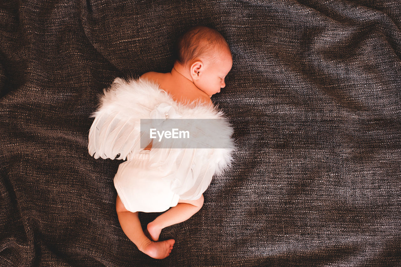 High angle view of baby girl sleeping on bed at home