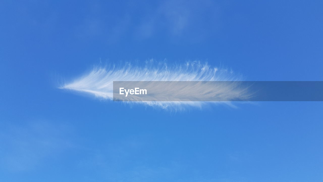LOW ANGLE VIEW OF VAPOR TRAIL IN BLUE SKY