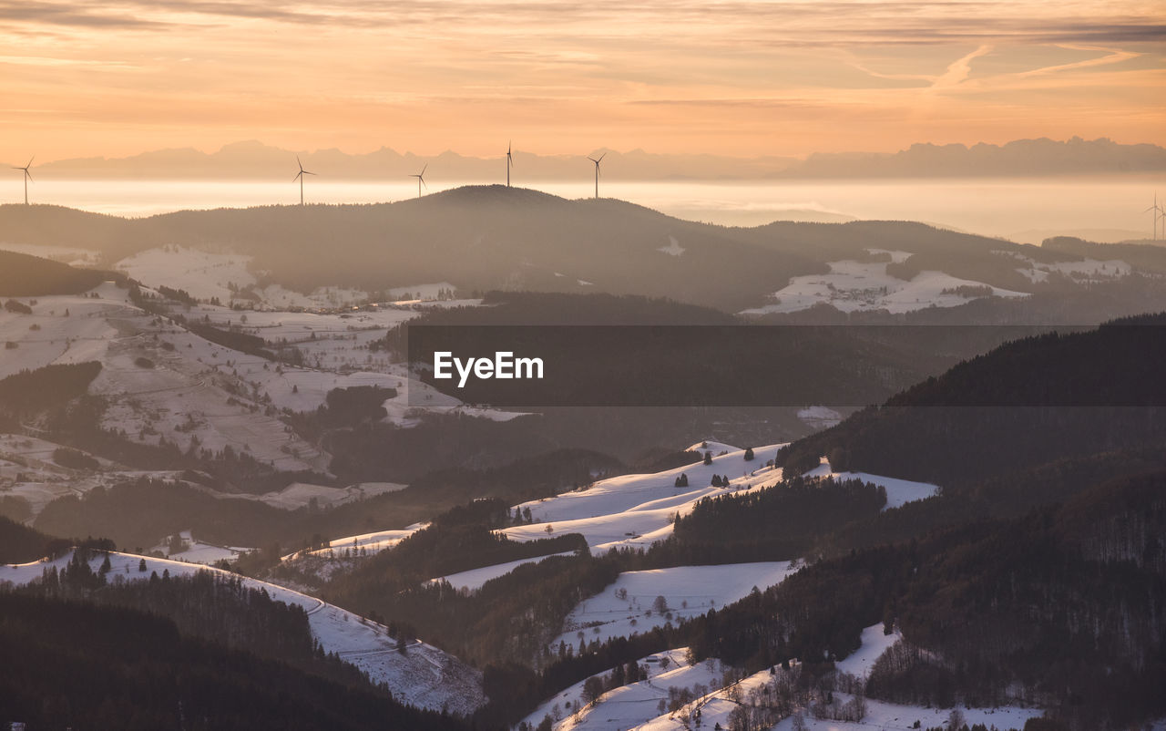 Scenic view of snowcapped mountains against sky during sunset