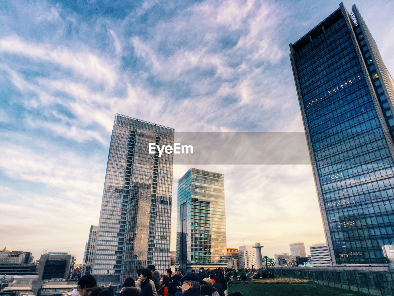 Low angle view of tall buildings against clouds