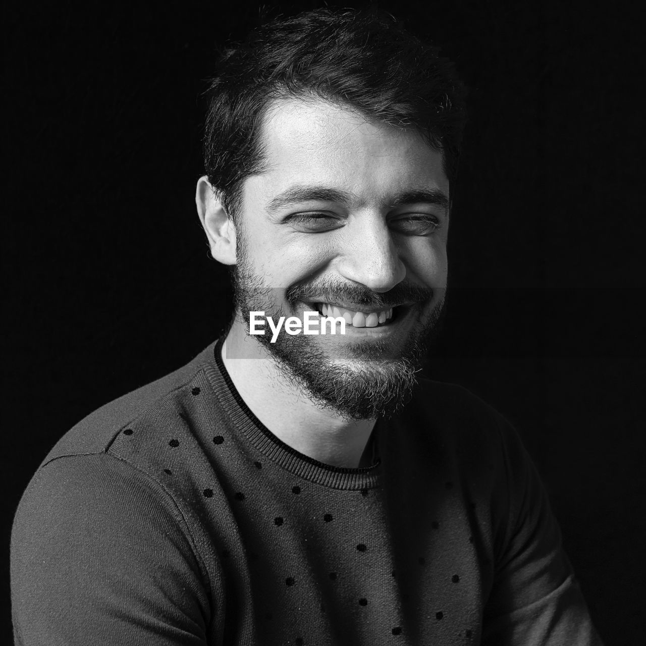 Portrait of young man against black background