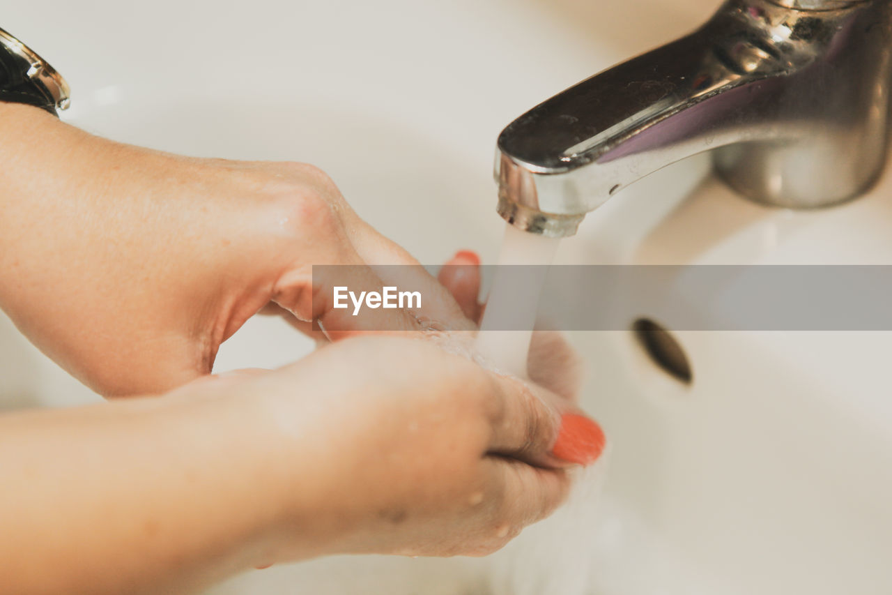 A woman washing her hands in the bathroom at home