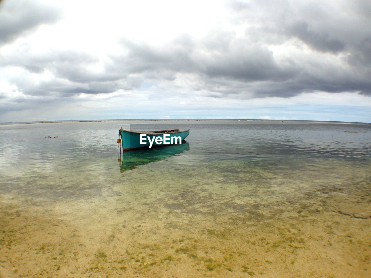 Boat in sea against cloudy sky