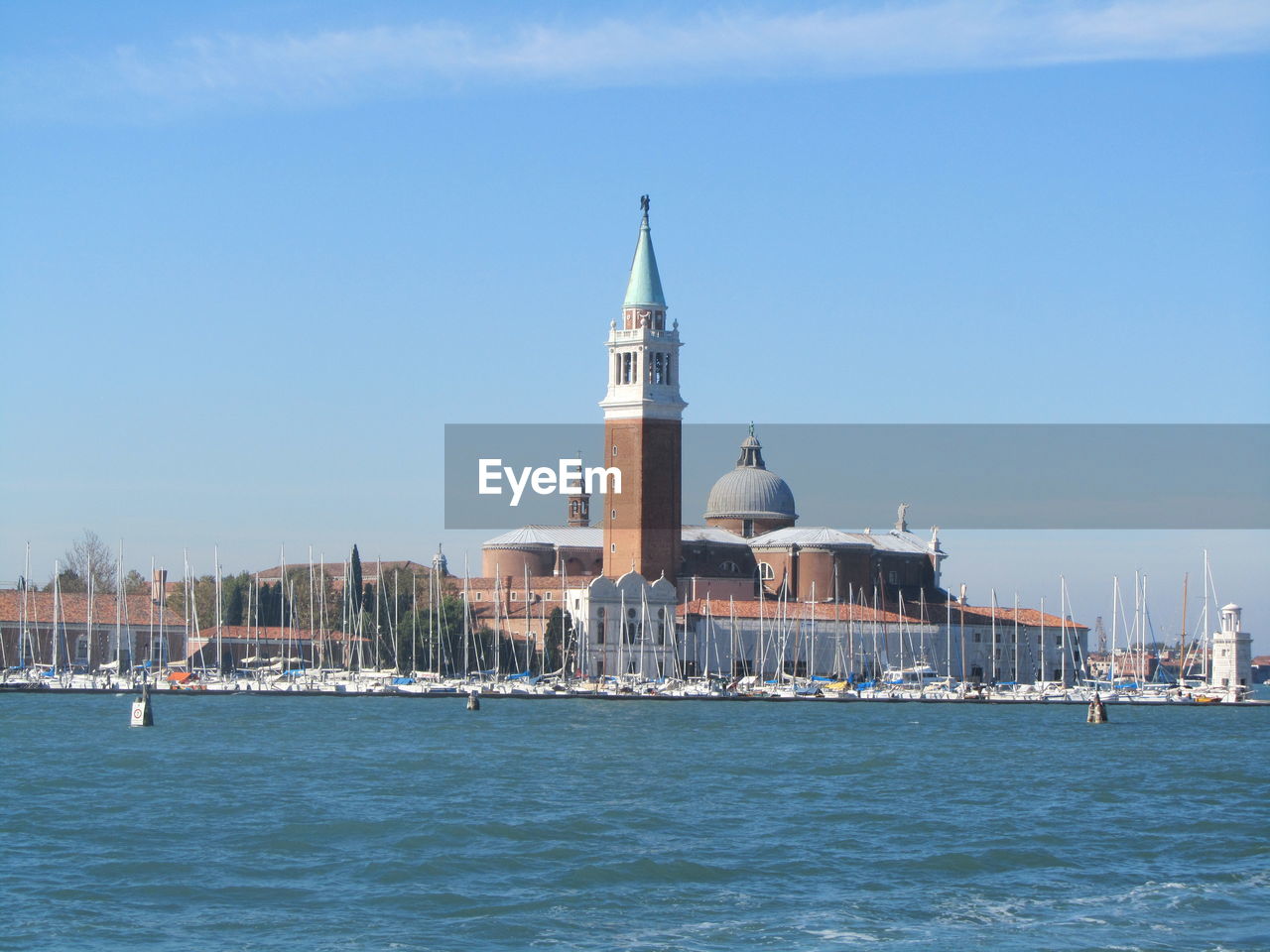 View of sea by city against blue sky