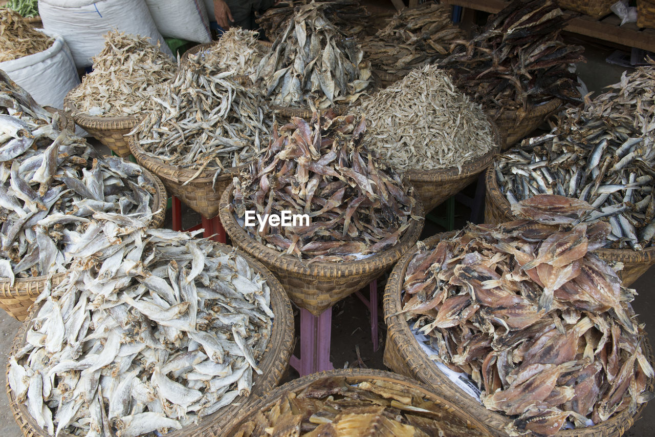 High angle view of dried fish in baskets at market for sale