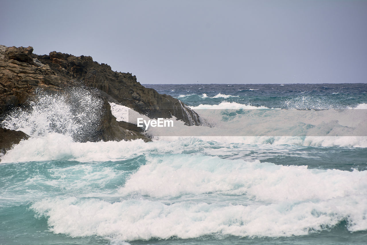 SEA WAVES SPLASHING AGAINST CLEAR SKY