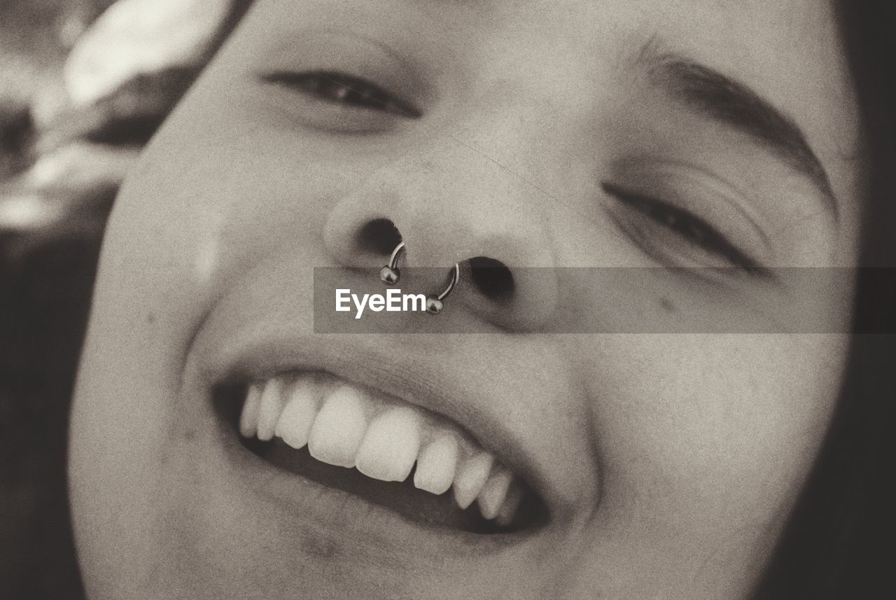 Close-up portrait of smiling young woman wearing nose ring