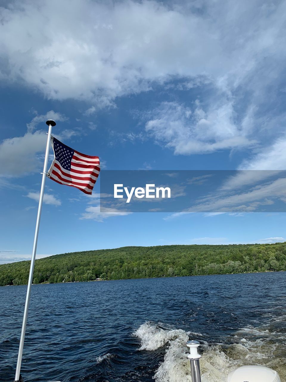 FLAG BY POLE AGAINST SKY