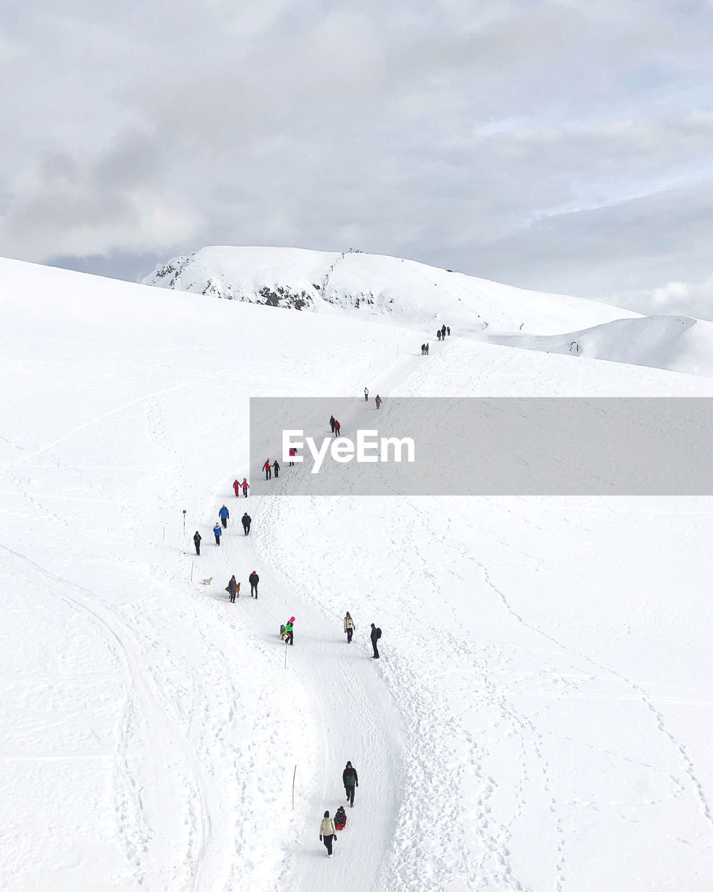 High angel view of person walking on snow covered land against sky