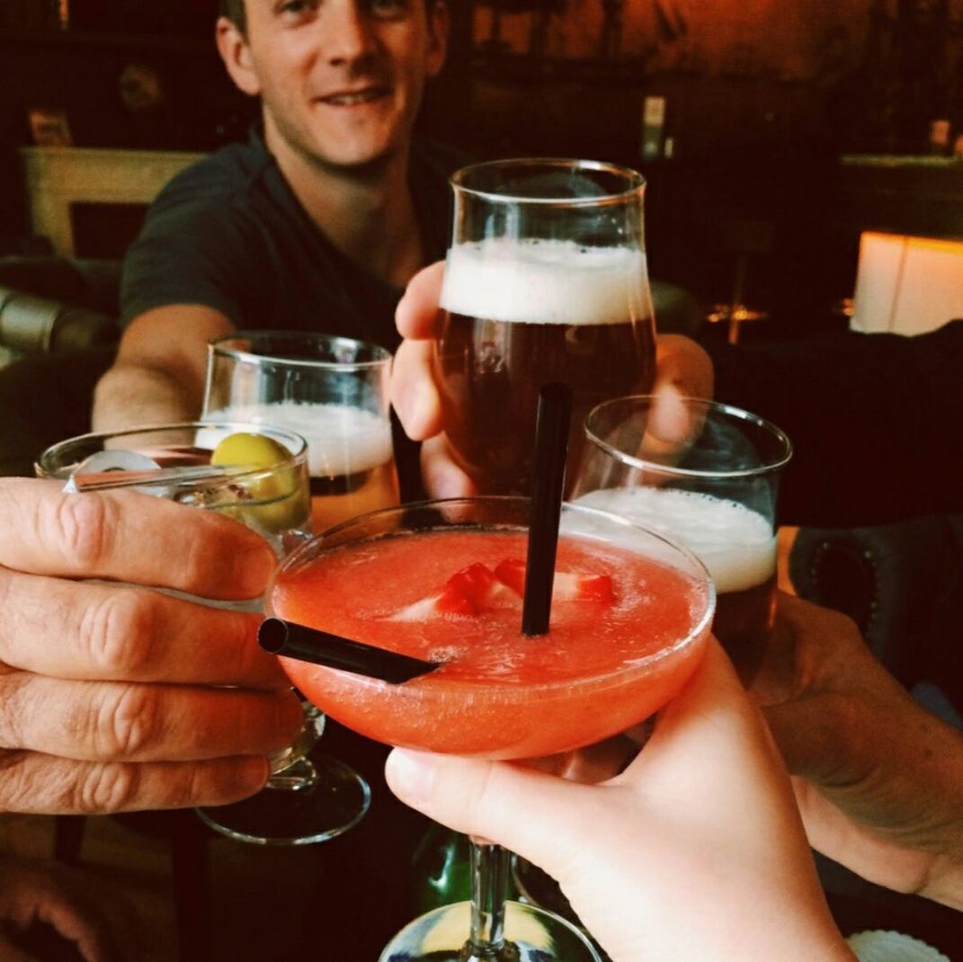 Cropped hands of friends toasting drinks at restaurant