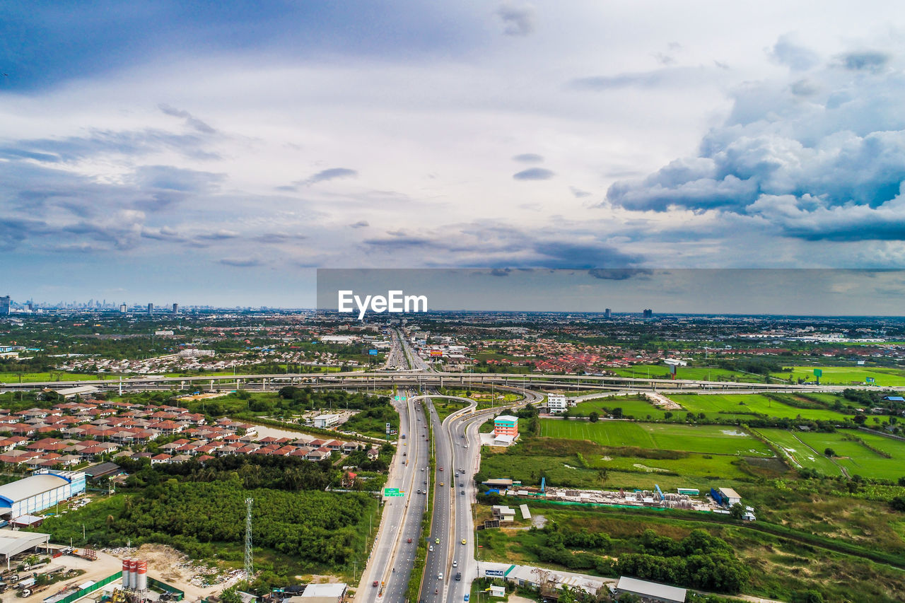 HIGH ANGLE VIEW OF TOWNSCAPE AND ROAD AGAINST SKY