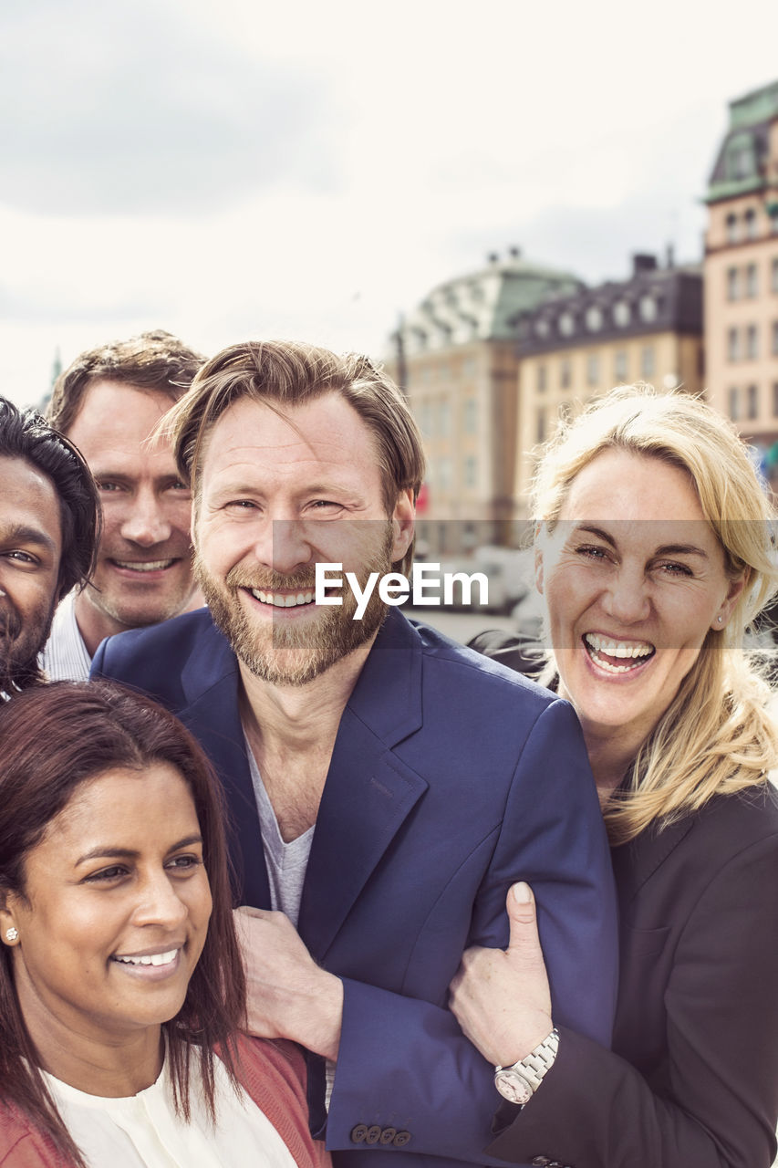 Portrait of happy group of business people standing together outdoors