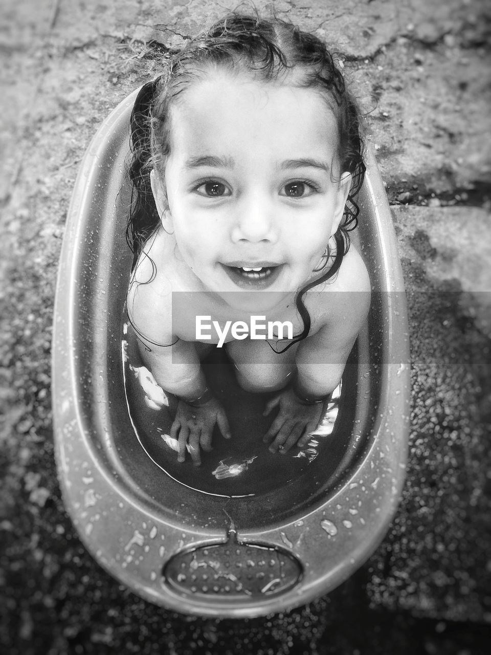 High angle portrait of cute baby girl sitting in bathtub