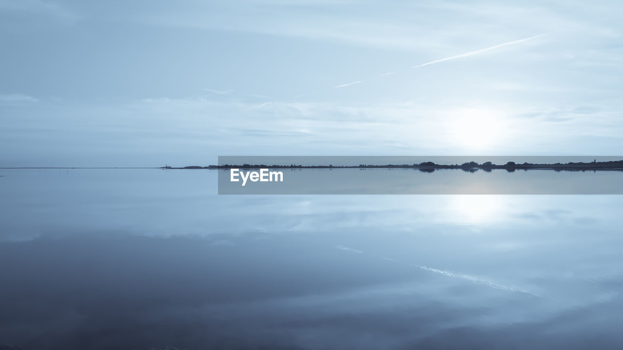 sky, water, cloud, beauty in nature, tranquility, scenics - nature, tranquil scene, reflection, nature, horizon, sea, idyllic, no people, day, horizon over water, outdoors, sunlight, non-urban scene, wave, sun, blue, ocean, environment