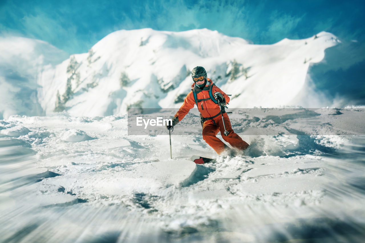 Low angle view of mature woman skiing on snow covered mountain