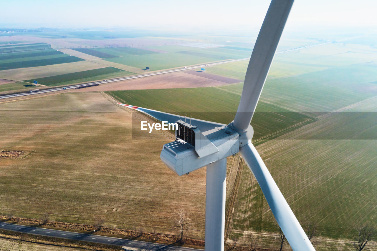 Aerial view of close up windmill turbine in countryside area, wind power 