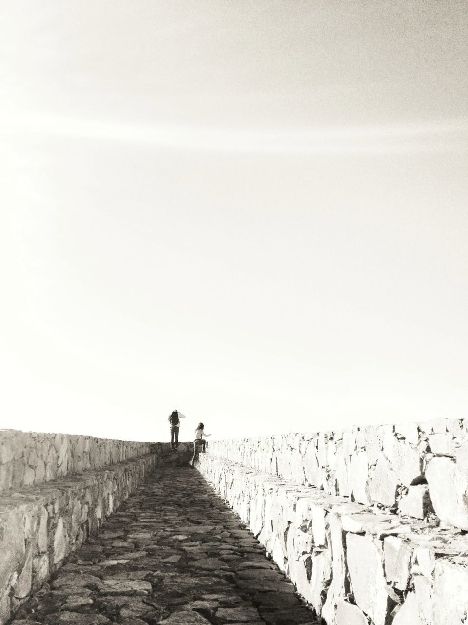 MEN WALKING ON FOOTPATH AGAINST SKY