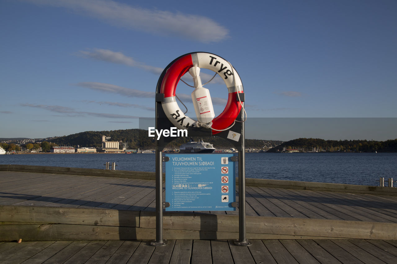 INFORMATION SIGN ON PIER AGAINST SKY