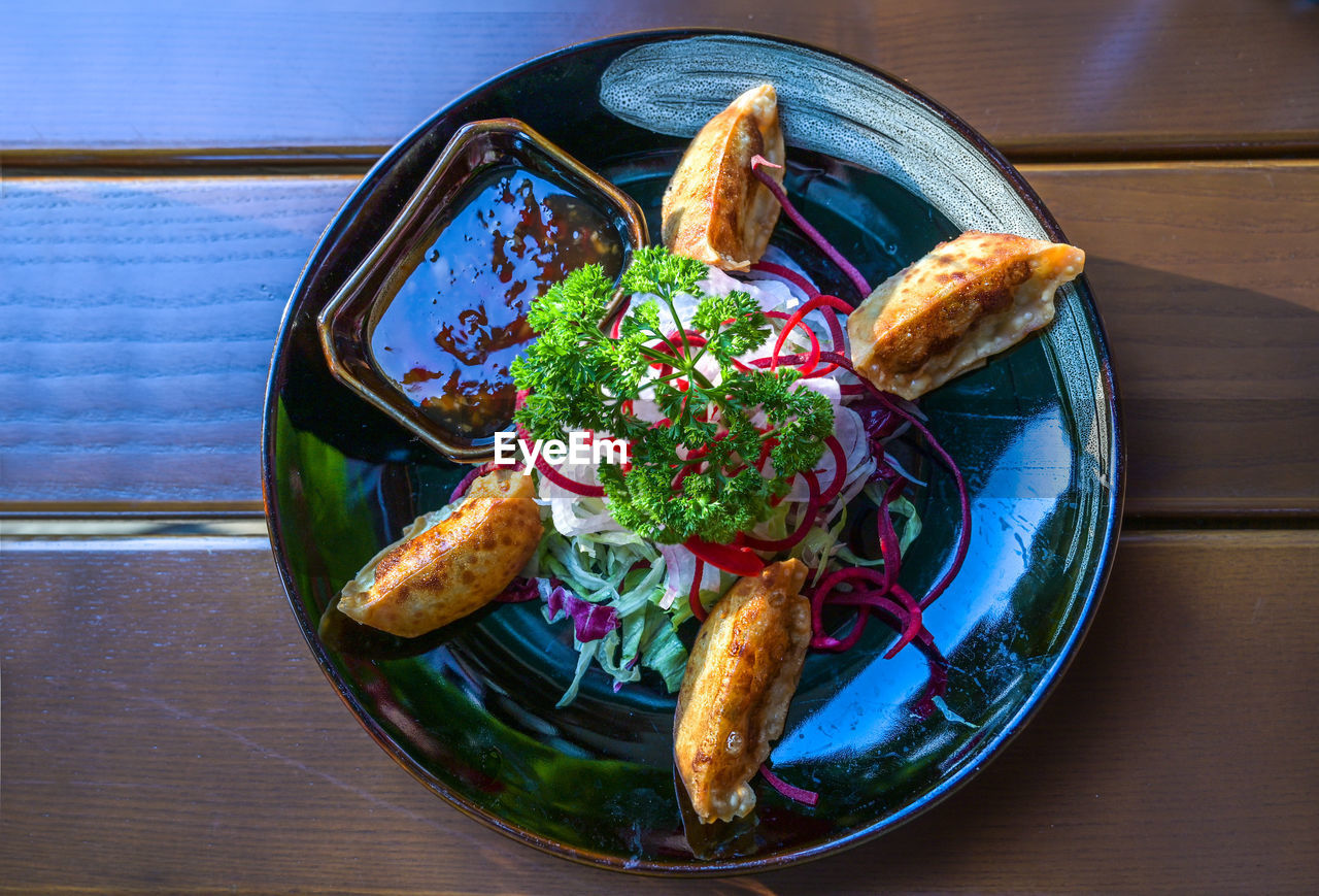 food and drink, food, healthy eating, freshness, table, fast food, wellbeing, lunch, vegetable, plate, meal, wood, indoors, no people, bowl, high angle view, dish, seafood, directly above, still life, serving size, bread, salad, cuisine, fruit, meat, herb