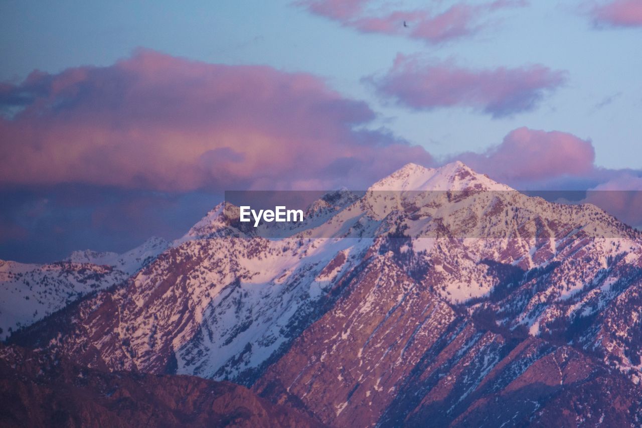 AERIAL VIEW OF SNOWCAPPED MOUNTAINS AGAINST SKY