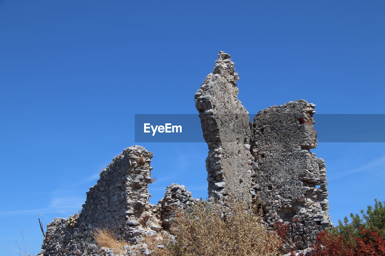 sky, blue, nature, clear sky, plant, no people, tree, low angle view, rock, history, travel destinations, architecture, the past, day, travel, outdoors, sunny, landmark, mountain, scenics - nature, built structure, tranquility, tourism, copy space, beauty in nature, land, ruins, sculpture