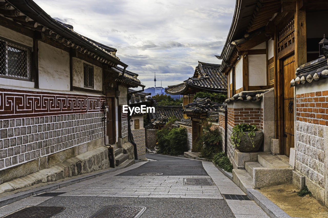 STREET AMIDST BUILDINGS AGAINST SKY