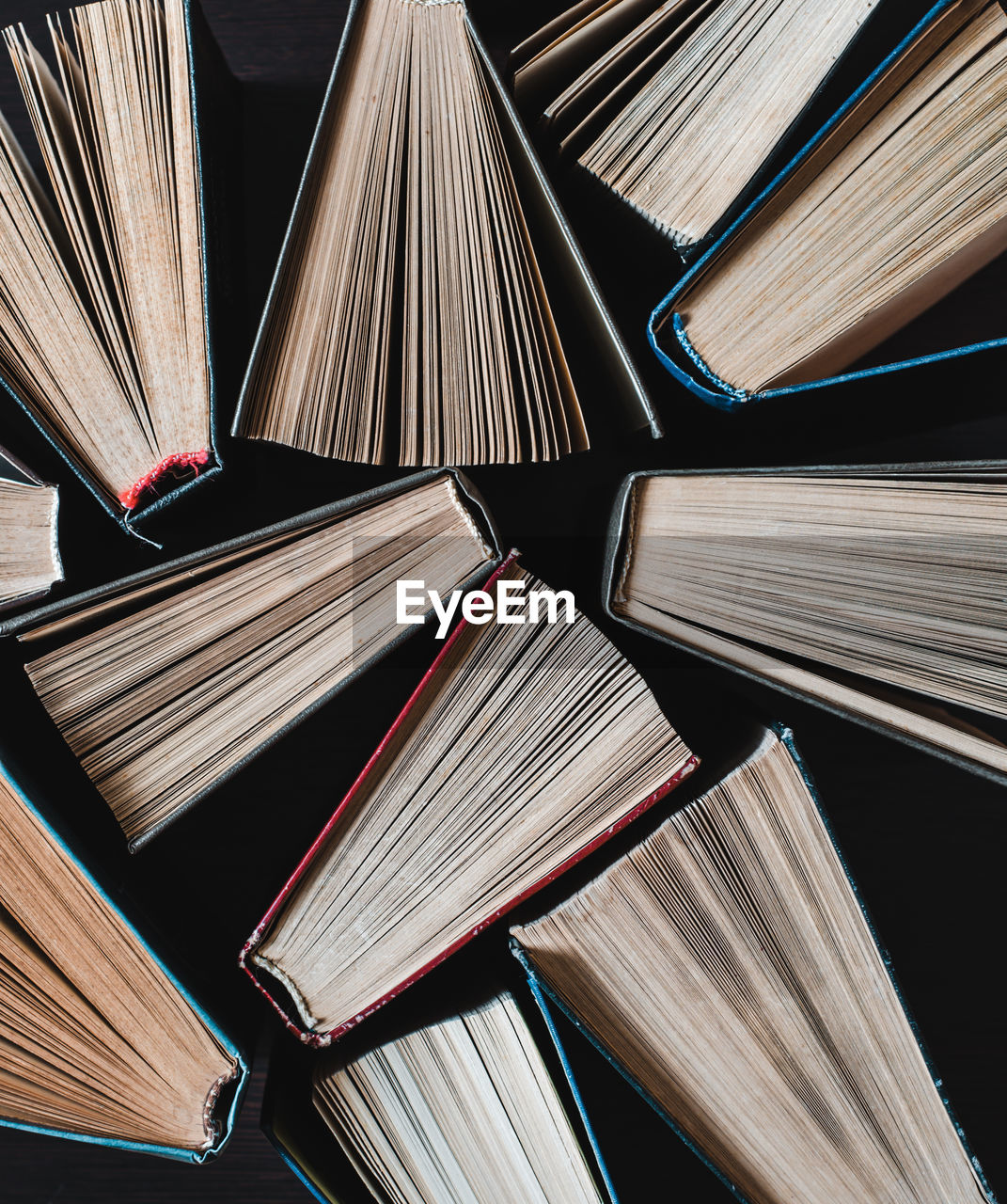 Parted books next to each other top view. background from multicolored old books.