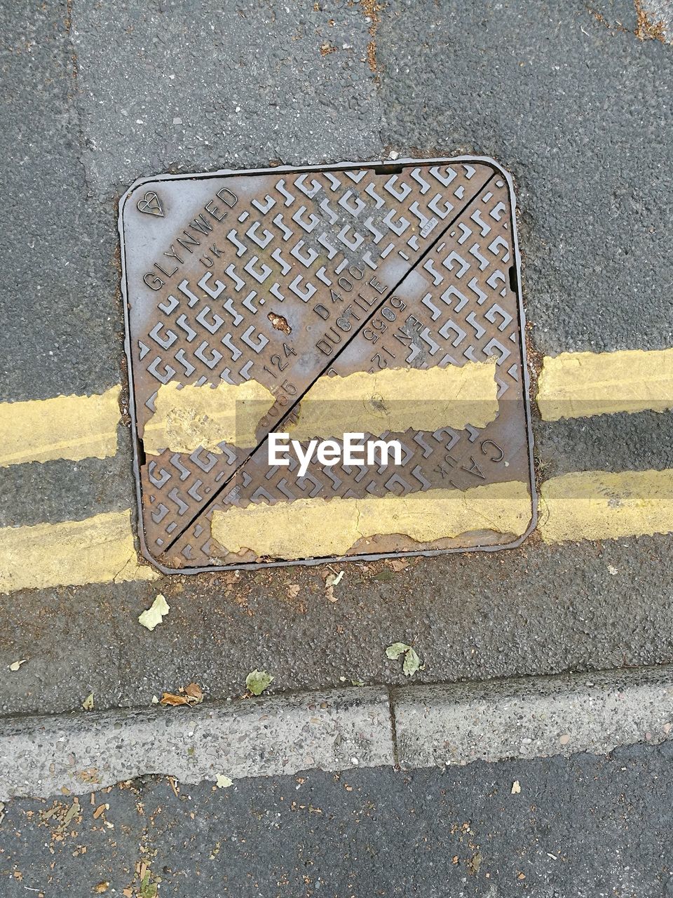 HIGH ANGLE VIEW OF MANHOLE ON ROAD