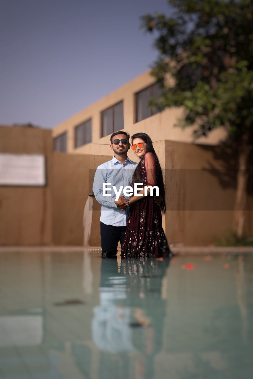 Young couple standing in swimming pool