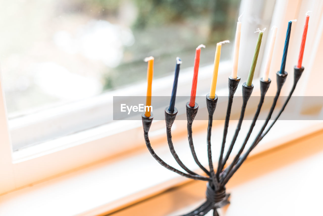 Menorah with unlit candles for hanukkah celebrations in a window.