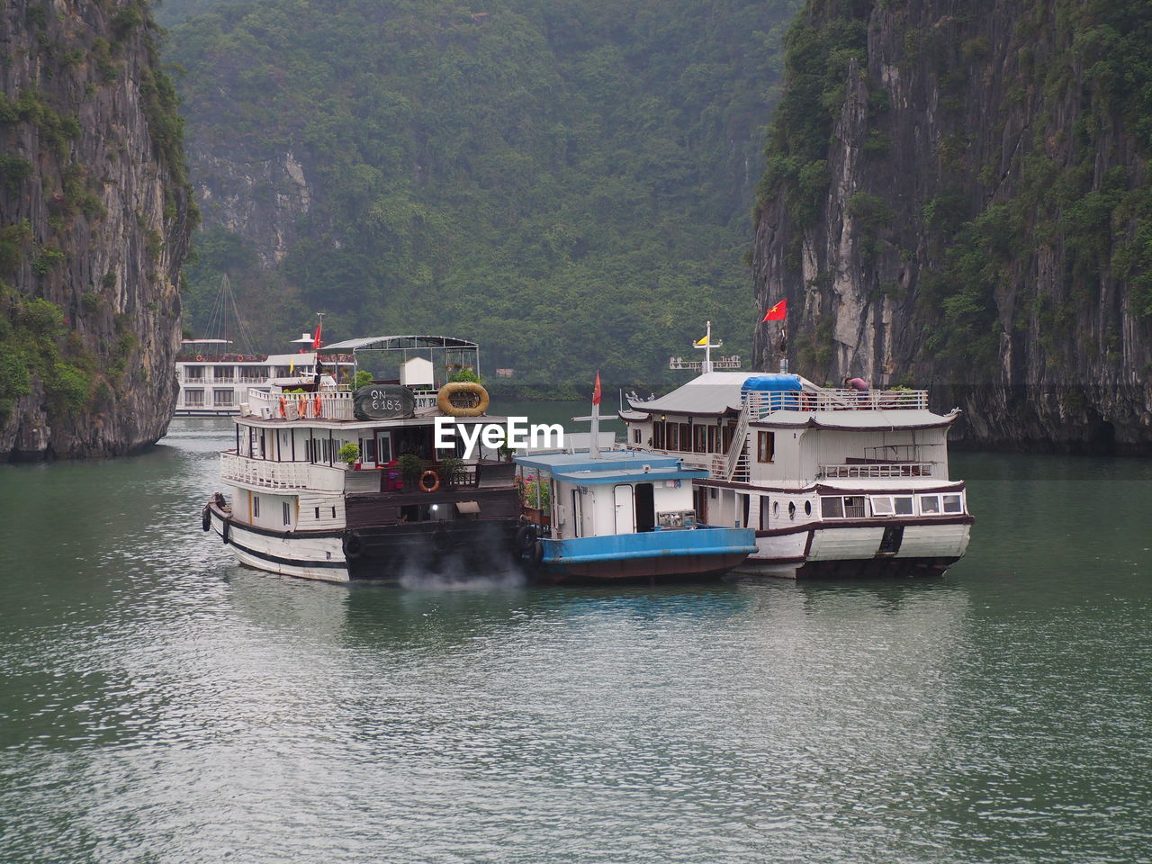 SHIP IN SEA AGAINST MOUNTAIN