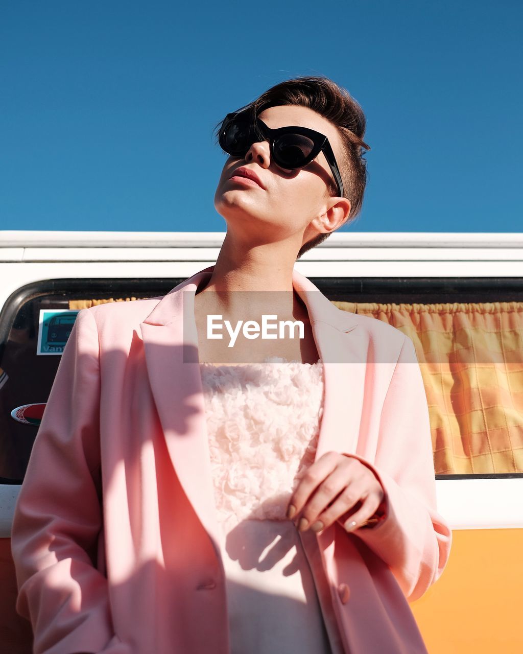 YOUNG WOMAN ON SUNGLASSES AGAINST SKY