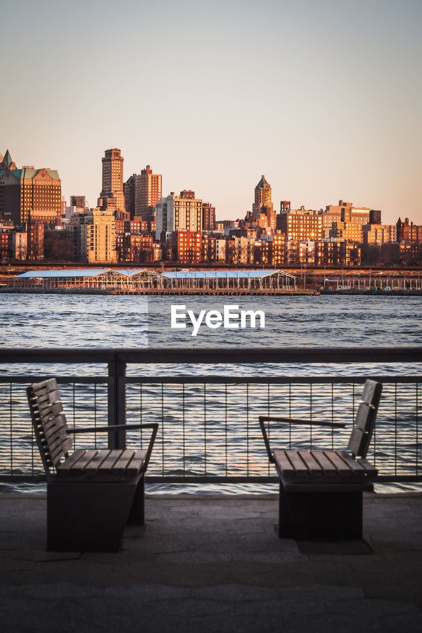 View of river and buildings against sky during sunset