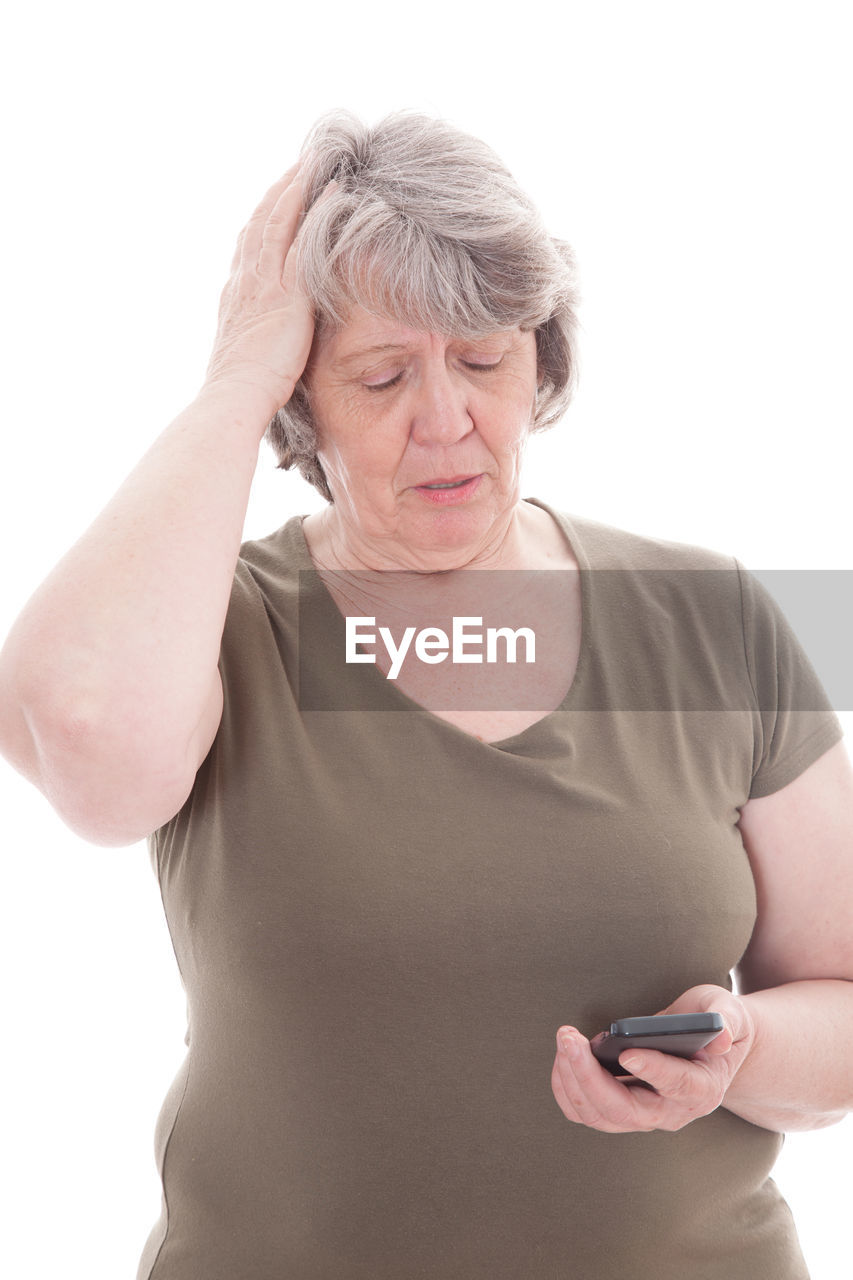 Senior woman using phone against white background