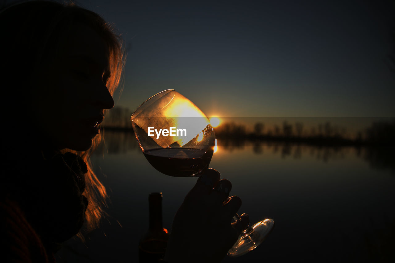 Reflection of man in water at sunset