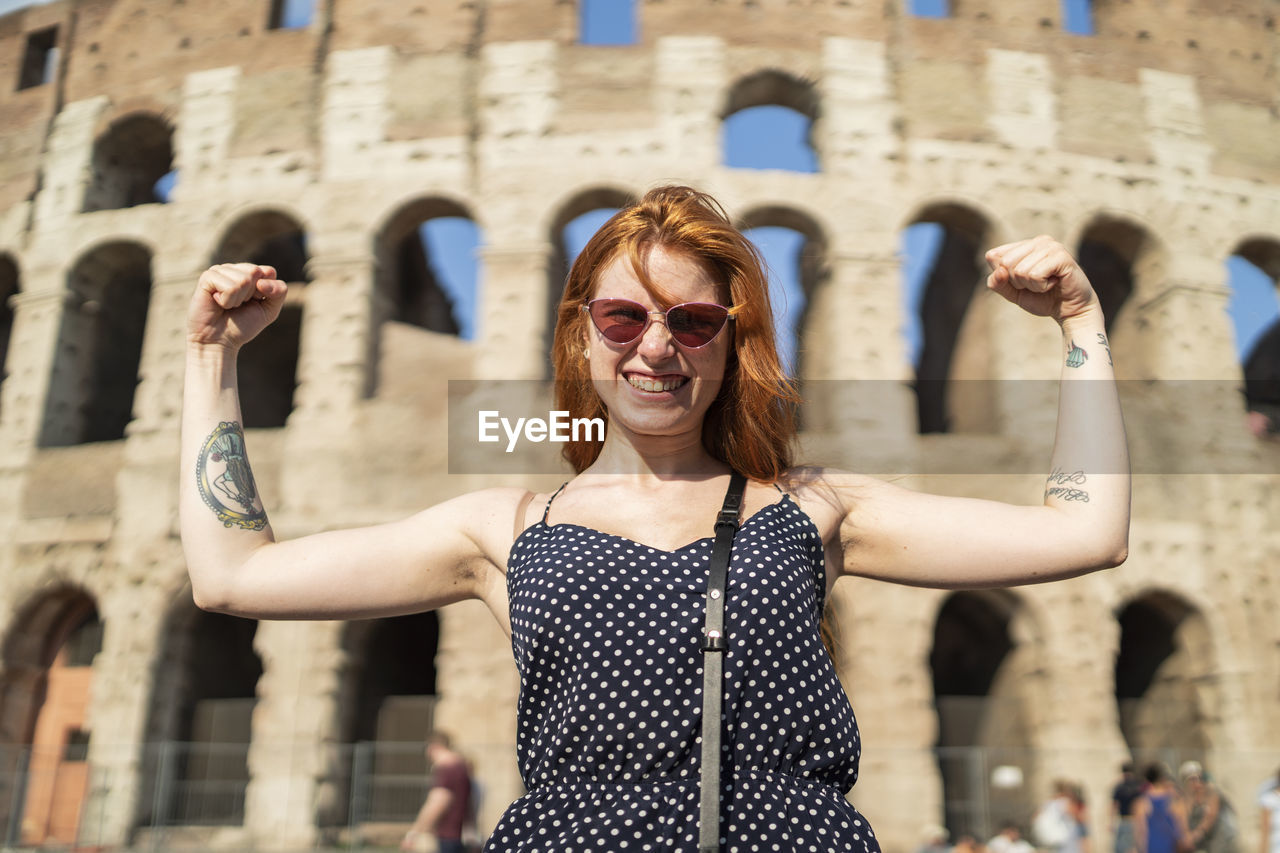 Powerful tourist flexing muscles near famous attraction