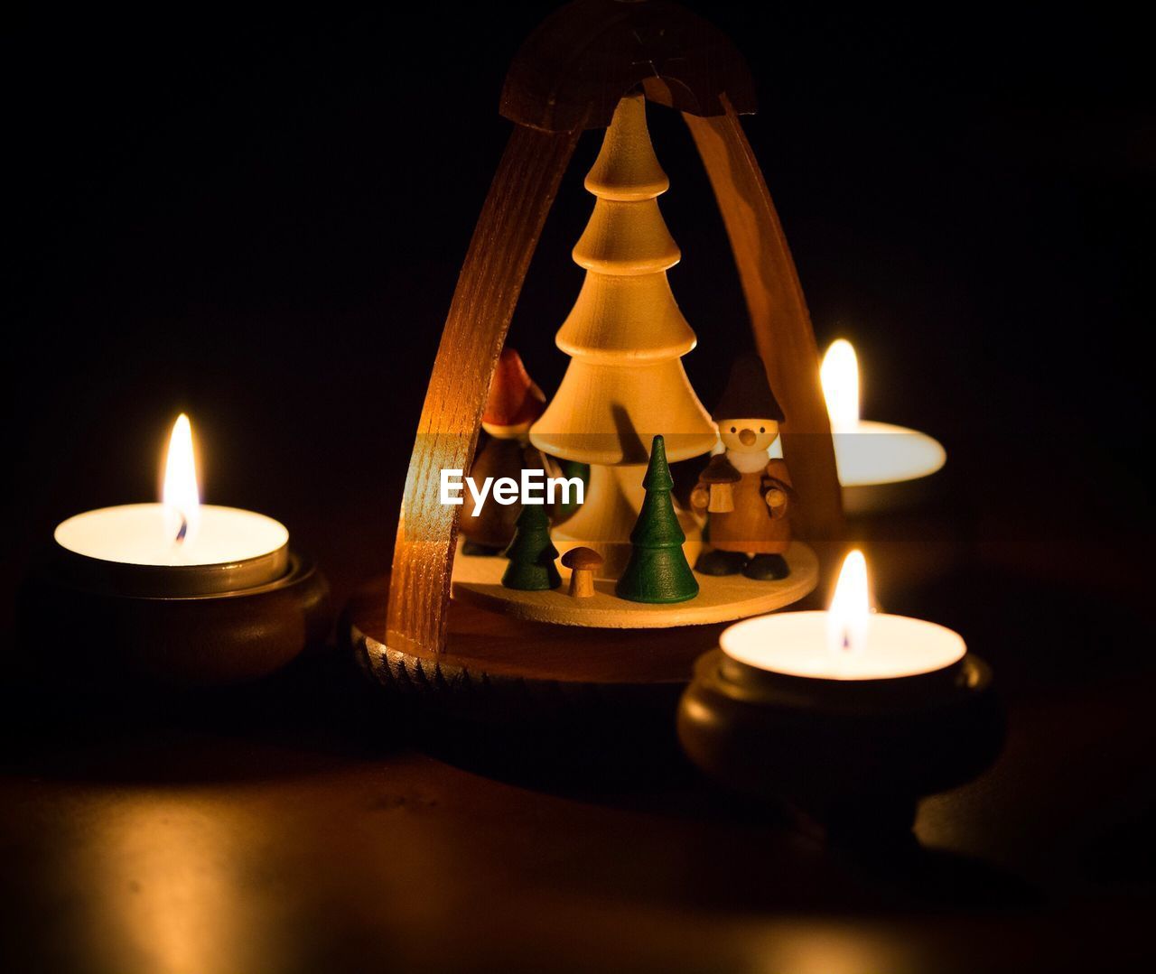 Close-up of christmas decoration with illuminated tea light candles on table