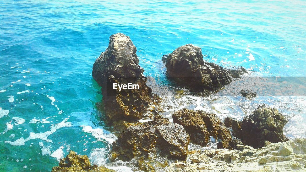 HIGH ANGLE VIEW OF ROCKS ON SHORE