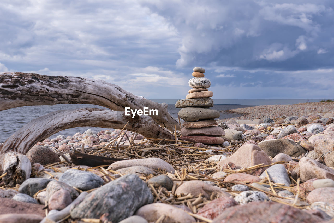 Stack of stones on rock against sky