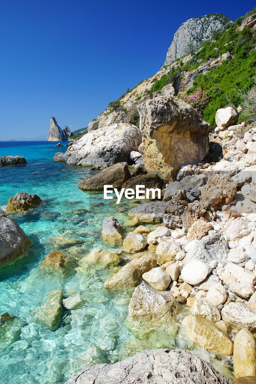 SCENIC VIEW OF SEA AND MOUNTAINS AGAINST CLEAR SKY