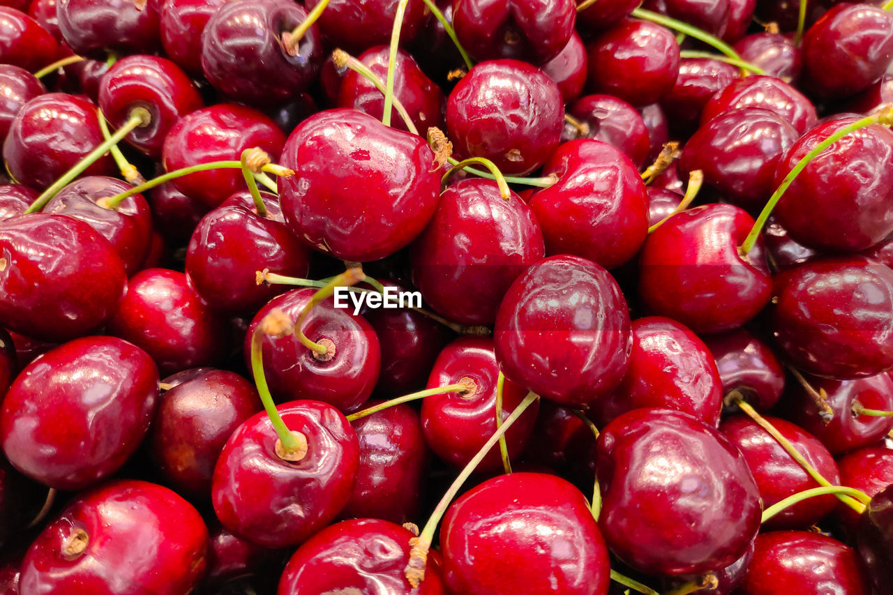 Close-up on a stack of cherries on a market stall.