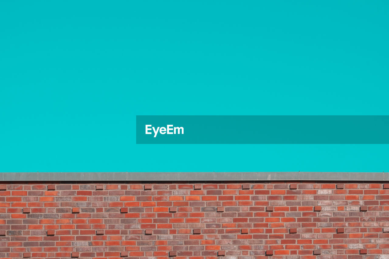 LOW ANGLE VIEW OF WALL AGAINST BLUE SKY