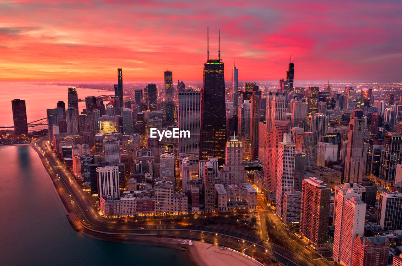 Aerial view of buildings in city against sky during sunset